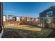 Fenced backyard with grass and view of modern townhomes on a bright day at 5866 Boston Ct, Denver, CO 80238