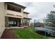 Backyard featuring a covered deck, seating area, and a trampoline for outdoor fun at 5866 Boston Ct, Denver, CO 80238