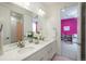 Modern bathroom with double sinks, quartz counters, and a view into a pink themed bedroom at 5866 Boston Ct, Denver, CO 80238