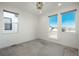 Bright, empty bedroom featuring neutral carpet, a modern chandelier, and three large windows with lovely views at 5866 Boston Ct, Denver, CO 80238