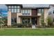 Modern two-story home featuring a stone facade, large windows, well-manicured lawn, and professional landscaping at 5866 Boston Ct, Denver, CO 80238