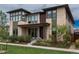 Modern two-story home featuring a stone facade, large windows, well-manicured lawn, and professional landscaping at 5866 Boston Ct, Denver, CO 80238