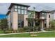 Two-story home featuring a stone facade, large windows, well-manicured lawn, and professional landscaping at 5866 Boston Ct, Denver, CO 80238