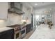 Gourmet kitchen features a stainless steel range hood and stove, marble countertops, and ample cabinet space at 5866 Boston Ct, Denver, CO 80238