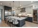 Modern kitchen featuring an island with seating, stainless steel appliances, a wine fridge, and custom cabinets at 5866 Boston Ct, Denver, CO 80238