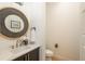 Stylish powder room with a round mirror, modern vanity, and elegant fixtures at 5866 Boston Ct, Denver, CO 80238