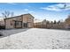 Large, snow-covered backyard with a fenced perimeter and view of adjacent house at 9421 Morning Glory Ln, Highlands Ranch, CO 80130