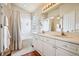 Bright bathroom featuring a double sink vanity, shower with curtain, and glass block window at 9421 Morning Glory Ln, Highlands Ranch, CO 80130