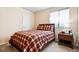 Bedroom featuring plaid bedding, a nightstand, and a window with blinds for natural light at 9421 Morning Glory Ln, Highlands Ranch, CO 80130