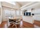 Bright dining area with hardwood floors and adjacent white kitchen with black appliances at 9421 Morning Glory Ln, Highlands Ranch, CO 80130