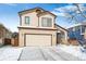 Charming two-story home featuring an attached garage, brick accents, and a snow-covered lawn at 9421 Morning Glory Ln, Highlands Ranch, CO 80130