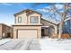 Charming two-story home featuring a two-car garage and landscaped yard during winter at 9421 Morning Glory Ln, Highlands Ranch, CO 80130