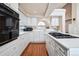 Bright kitchen features white cabinets, countertops, stainless steel appliances and wood-look flooring at 9421 Morning Glory Ln, Highlands Ranch, CO 80130