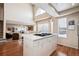 Open kitchen featuring an island gas cooktop, hardwood floors, high ceilings, and bright natural light at 9421 Morning Glory Ln, Highlands Ranch, CO 80130