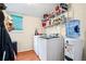 Well-organized laundry room with washer, dryer, storage shelving, and water cooler at 9421 Morning Glory Ln, Highlands Ranch, CO 80130