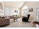 Bright living room with vaulted ceilings, large windows, and neutral-toned furniture at 9421 Morning Glory Ln, Highlands Ranch, CO 80130