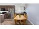Open concept dining room features hardwood floors, wooden table, and dark wood cabinetry at 9628 Albion Ln, Thornton, CO 80229