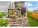 Landscaped exterior showcasing a charming flower garden with stone retaining wall and vibrant purple clematis at 9628 Albion Ln, Thornton, CO 80229