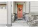 A welcoming front entryway featuring a salmon colored front door and stone accents at 9628 Albion Ln, Thornton, CO 80229