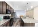 Open kitchen with granite counters, stainless appliances, dark wood cabinets, and eating area at 9628 Albion Ln, Thornton, CO 80229