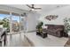 Bright living room with a sliding glass door, decorative art, and wood flooring at 9628 Albion Ln, Thornton, CO 80229