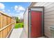 A backyard storage shed with a red door, offering convenient storage space for outdoor equipment and tools at 9628 Albion Ln, Thornton, CO 80229