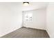 Bright bedroom featuring gray carpet, crisp white trim, and a window view at 14126 W Harvard Pl, Lakewood, CO 80228