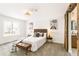 A bright bedroom featuring neutral decor and a rustic barn door to the bathroom at 14126 W Harvard Pl, Lakewood, CO 80228