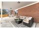 Covered patio with brick wall, stylish furniture, area rug, and wintery backyard views at 14126 W Harvard Pl, Lakewood, CO 80228