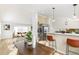 Open-concept dining area seamlessly connects to living room and kitchen with a breakfast bar and stainless steel appliances at 14126 W Harvard Pl, Lakewood, CO 80228