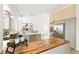 Modern kitchen showcases a wood-topped island with stainless steel appliances and open layout flowing into the living area at 14126 W Harvard Pl, Lakewood, CO 80228