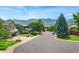 Neighborhood street view with lush green trees and beautiful mountain backdrop on clear day at 14126 W Harvard Pl, Lakewood, CO 80228