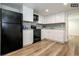 Modern basement kitchen with white cabinets and black appliances at 1875 Jay St, Lakewood, CO 80214
