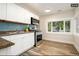 Updated kitchen with white cabinets, granite countertops, and blue tile backsplash at 1875 Jay St, Lakewood, CO 80214