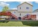 Backyard view featuring a two-story home with lawn, dual wooden decks, and sliding glass doors at 16304 10Th St, Mead, CO 80542