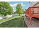 A spacious backyard featuring a large green lawn, a white fence, and a red deck, perfect for outdoor activities at 16304 10Th St, Mead, CO 80542