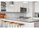 Close up of kitchen with modern appliances, white cabinets and island with seating at 20 Wilcox St # 403, Castle Rock, CO 80104