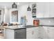 Modern kitchen with white cabinets, grey countertops, stainless steel appliances, and open shelving at 20 Wilcox St # 403, Castle Rock, CO 80104