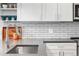 Close-up of kitchen featuring stainless steel sink, white cabinets, grey counter tops and subway tile backsplash at 20 Wilcox St # 403, Castle Rock, CO 80104