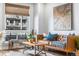 Sunlit living room features modern decor, leather couch, wood accents and large windows at 20 Wilcox St # 403, Castle Rock, CO 80104