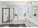 Bright bathroom with a bathtub, walk-in shower, dual vanity, elegant fixtures, and sleek tile work at 904 Sundown Way, Erie, CO 80516