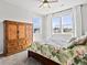 Bright bedroom featuring a ceiling fan, natural light, floral bedspread, and wooden dresser at 904 Sundown Way, Erie, CO 80516