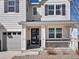 Detailed view of the home's entrance, featuring a modern black door, white pillars, and an ADT security sign at 904 Sundown Way, Erie, CO 80516