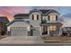 Charming two-story home featuring a three-car garage, modern door, and inviting front porch, perfect for suburban living at 904 Sundown Way, Erie, CO 80516