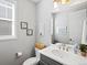 Cozy half bathroom with a charming decor, gray vanity, white countertop, and framed wall art at 904 Sundown Way, Erie, CO 80516
