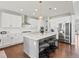 Open-concept kitchen featuring a large island, stainless steel appliances, white cabinets, and hardwood floors at 904 Sundown Way, Erie, CO 80516