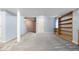 Spacious basement showcasing gray carpet, light blue walls, support beams and built-in wooden shelving at 19135 E Hickock Dr, Parker, CO 80134