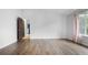 Bedroom with wood floors and light pink curtains next to an open door that leads to the hallway at 19135 E Hickock Dr, Parker, CO 80134