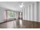 A well-lit bedroom with hard wood floors, a ceiling fan, and a large window with pink curtains at 19135 E Hickock Dr, Parker, CO 80134
