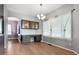 Bright dining area with custom cabinets, modern chandelier, large windows, and hardwood floors at 19135 E Hickock Dr, Parker, CO 80134